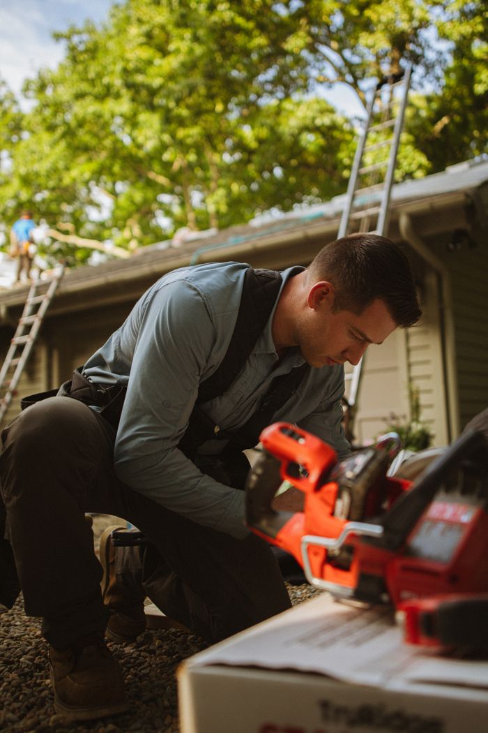 A construction worker using tools during a roofing project outdoors in Cashiers, North Carolina.