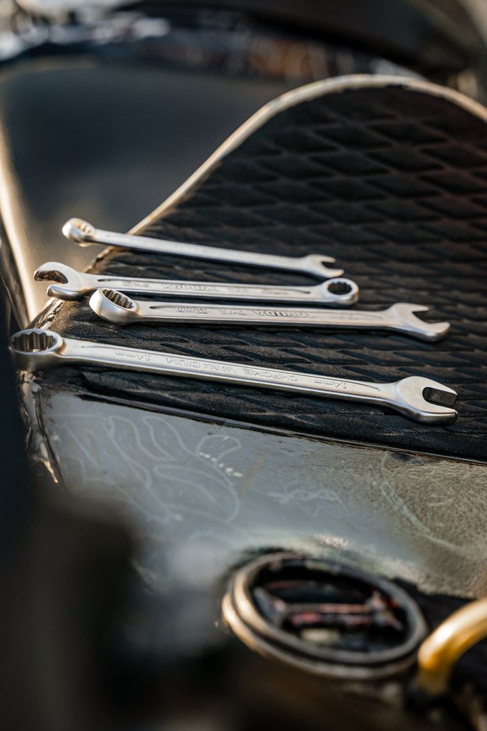 A set of polished wrenches displayed on a textured black surface, ideal for tool-related themes.